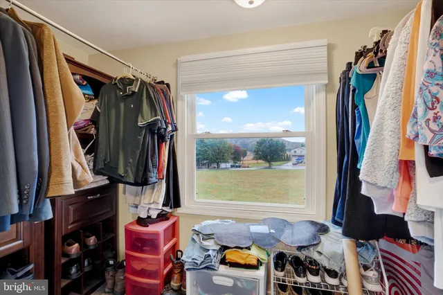 a view of walk in closet with clothes and shoes