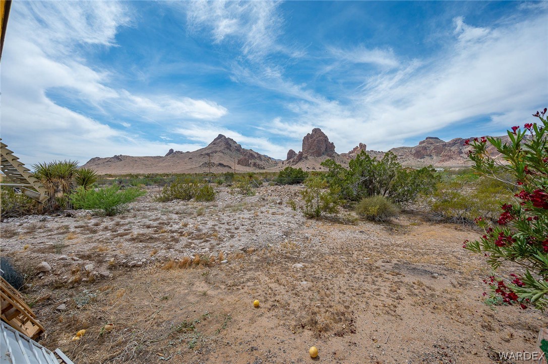 2465 Egar Road Golden Valley, AZ 86413 - Photo 49 of 98 Expansive desert landscape featuring natural rock formations and varied scrub vegetation under a blue sky with clouds