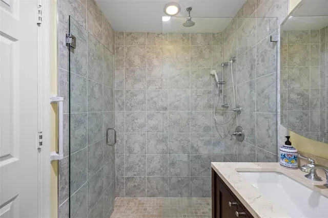 a bathroom with a sink shower and a mirror