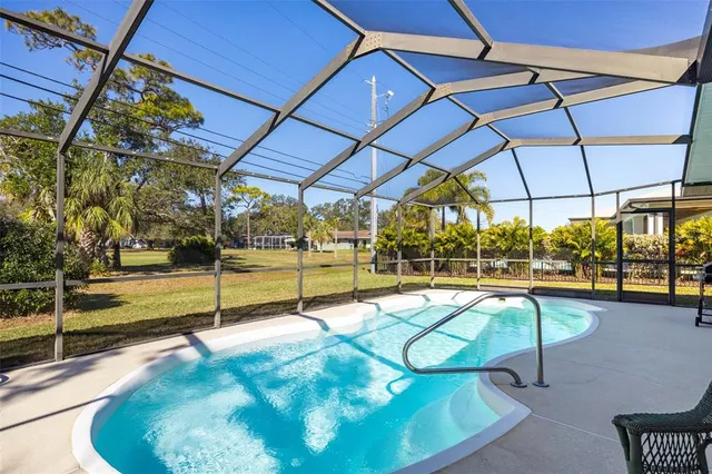 a view of a swimming pool with a patio and a yard