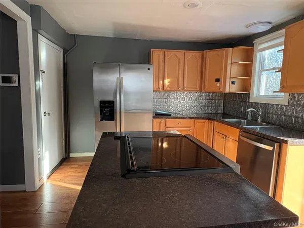 a view of a kitchen with stainless steel appliances granite countertop a sink and cabinets