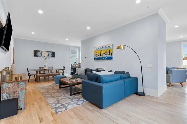 a living room with furniture a flat screen tv and a floor to ceiling window