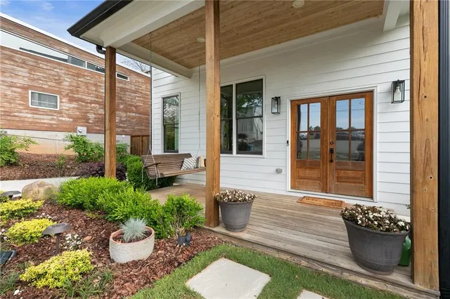 a view of a patio with couple of chairs and a potted plant