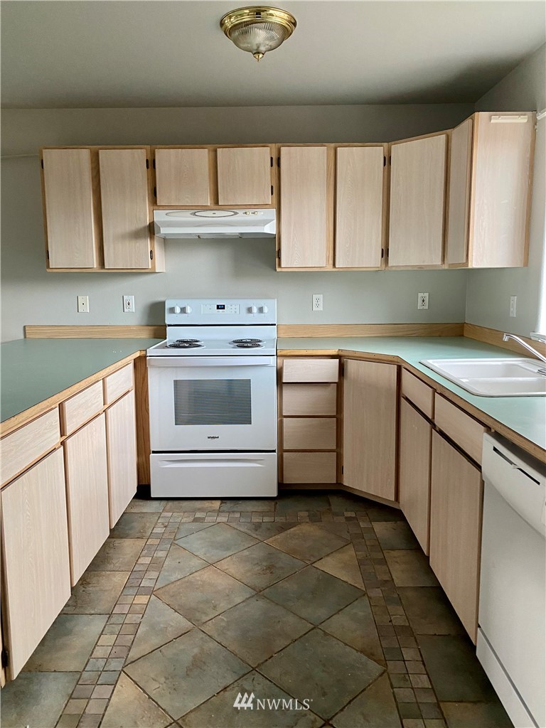 3966 Broadmoor Loop Bremerton, WA 98310 - Photo 11 of 32 a kitchen with stainless steel appliances a sink stove and cabinets