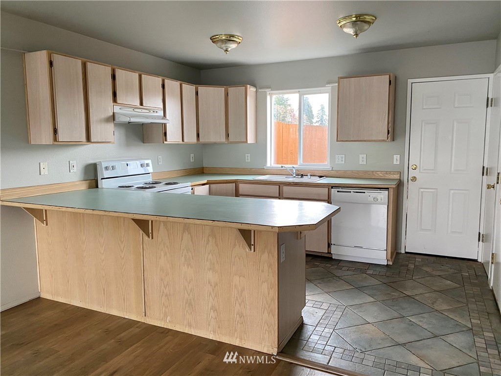 3966 Broadmoor Loop Bremerton, WA 98310 - Photo 12 of 32 a kitchen with stainless steel appliances granite countertop a sink a stove a refrigerator and cabinets
