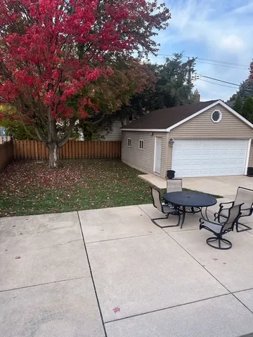 a view of a patio with table and chairs with wooden fence and plants