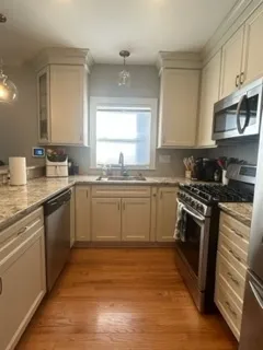 a kitchen with stainless steel appliances granite countertop a sink stove a refrigerator and cabinets