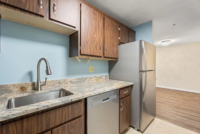 a kitchen with stainless steel appliances granite countertop a refrigerator sink and cabinets