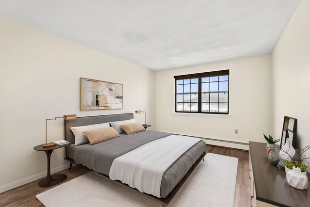 a bedroom with a bed and a painting on the wall