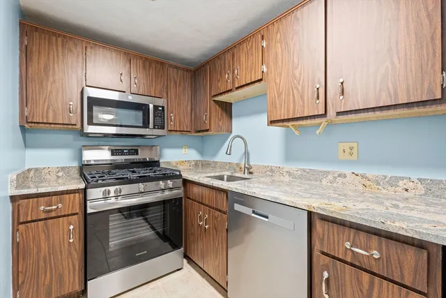 a kitchen with granite countertop wooden cabinets and a stove top oven