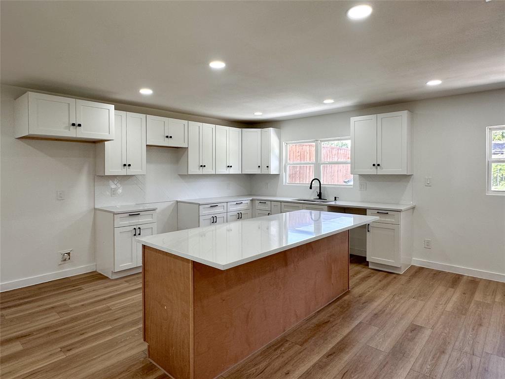 809 Longbeach Drive Garland, TX 75043 - Photo 3 of 18 Kitchen featuring light wood-style flooring, a center island, white cabinets, and recessed lighting