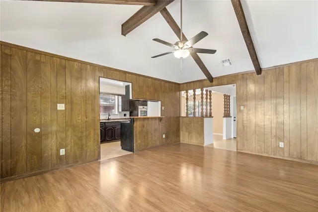 a view of a big room with wooden floor and windows