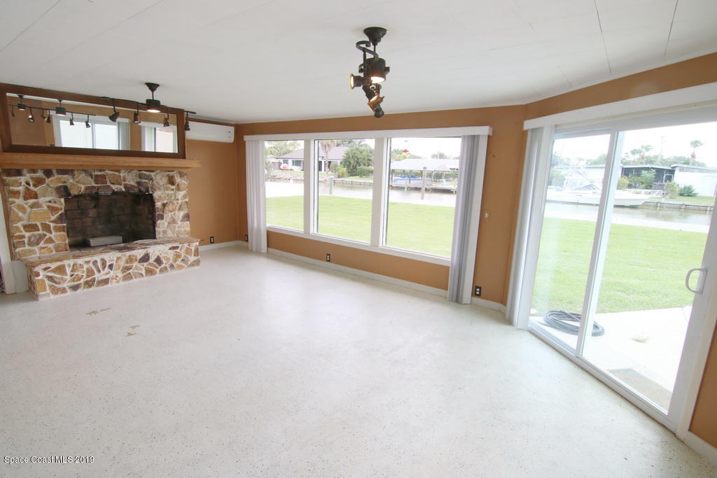 945 Trinidad Road Cocoa Beach, FL 32931 - Photo 11 of 34 a view of an empty room with a fireplace and a window