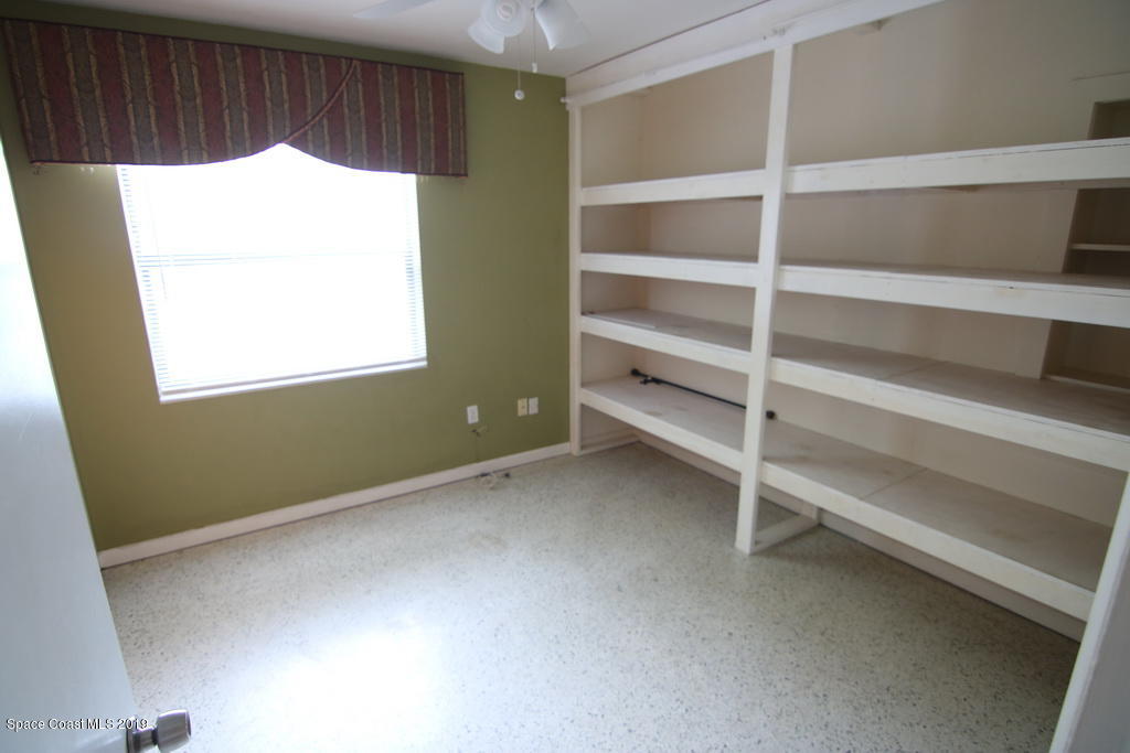 945 Trinidad Road Cocoa Beach, FL 32931 - Photo 18 of 34 a room with a wooden floor and a window