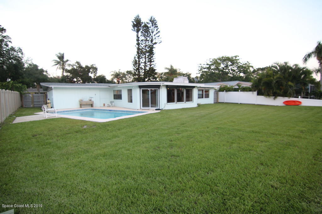 945 Trinidad Road Cocoa Beach, FL 32931 - Photo 27 of 34 a view of a house with a yard and sitting area