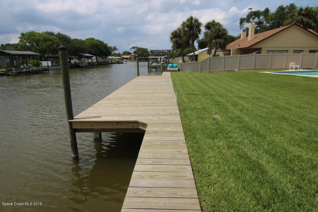 945 Trinidad Road Cocoa Beach, FL 32931 - Photo 30 of 34 a swimming pool with outdoor seating and lake view