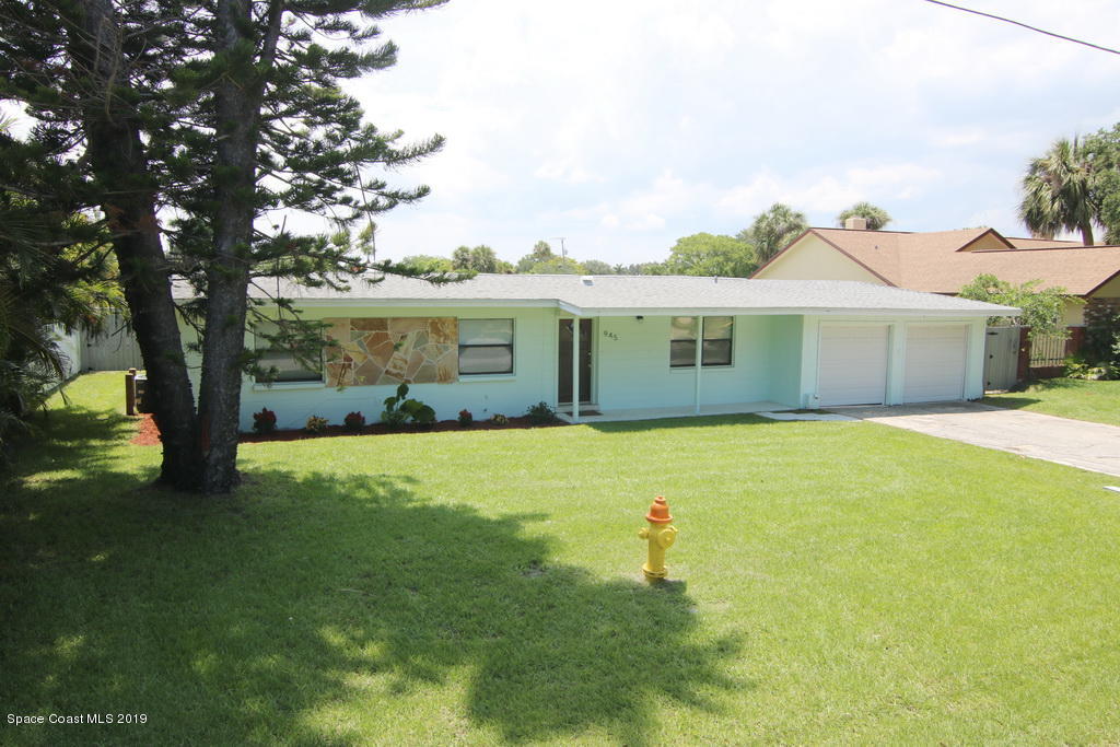 945 Trinidad Road Cocoa Beach, FL 32931 - Photo 34 of 34 a front view of a house with a garden