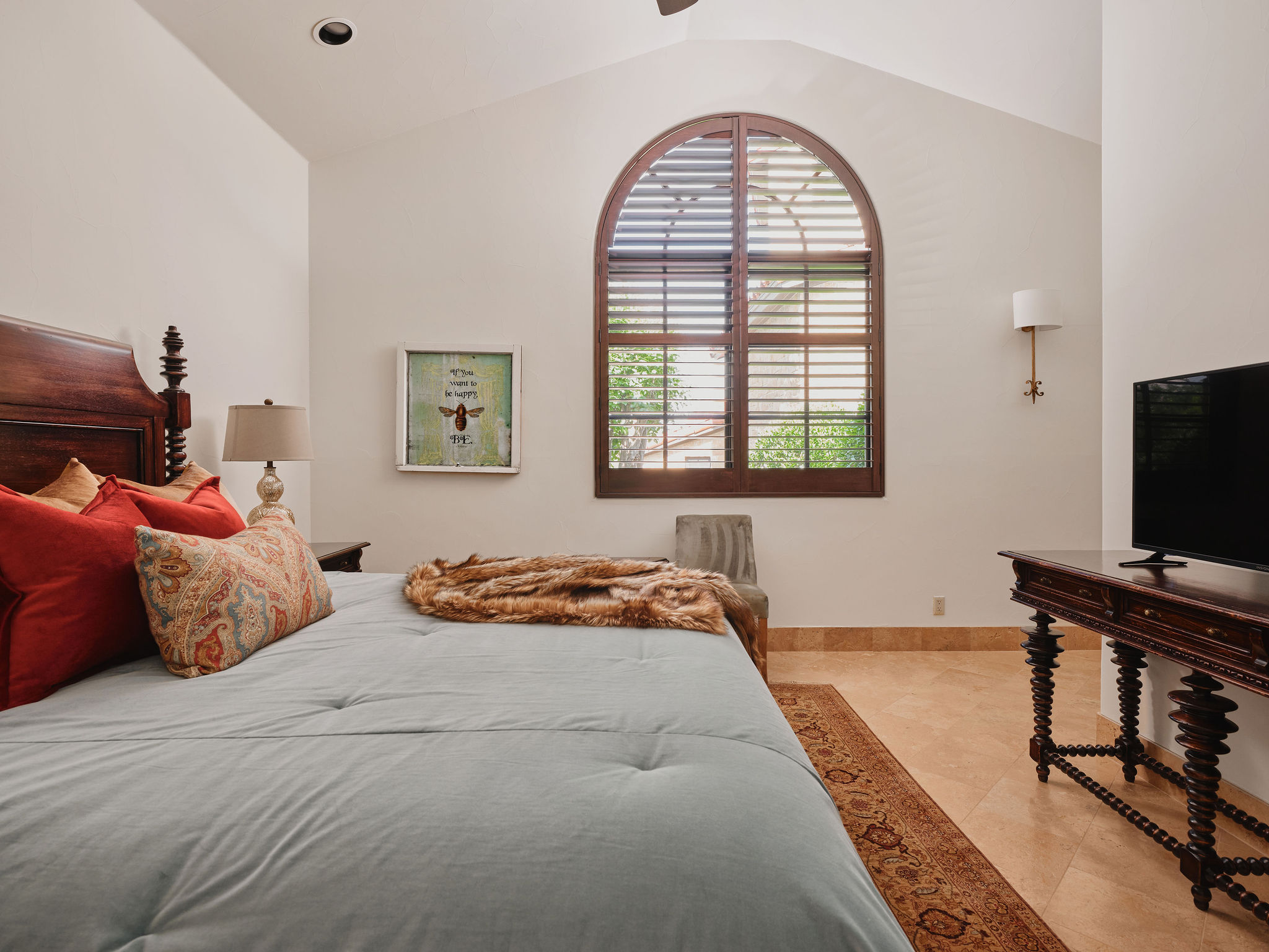 433 Brandon Way Austin, TX 78733 - Photo 35 of 40 Architectural details like a vaulted ceiling and an arched window with wooden shutters define this inviting bedroom.