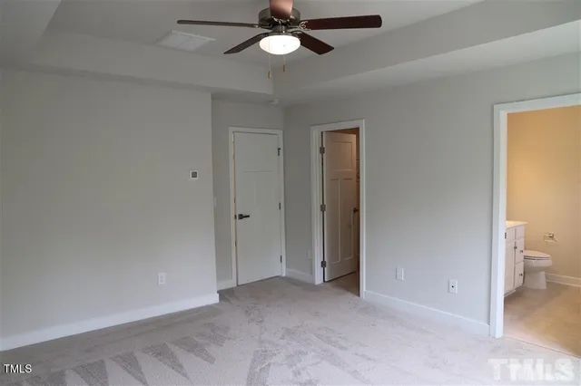 a view of a room with a ceiling fan and a bathroom