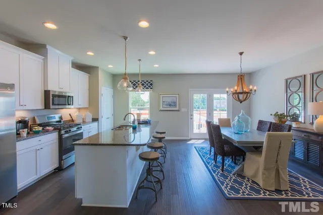 a living room with granite countertop furniture a dining table wooden floor and a chandelier