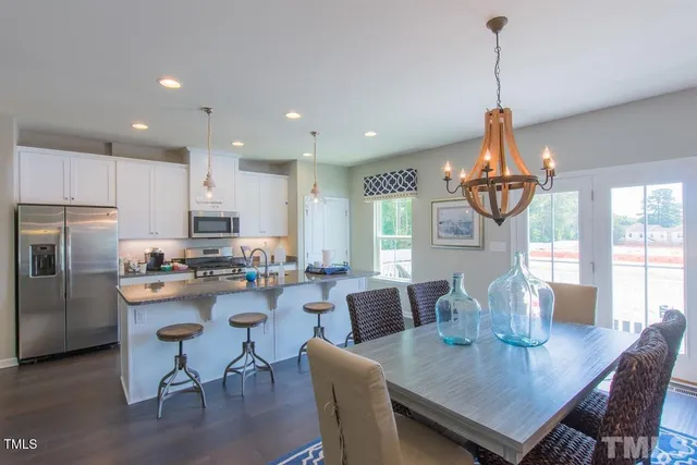 a view of a dining room with furniture a chandelier and wooden floor