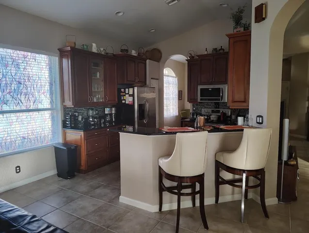 a bed sitting in a bedroom and a lamp next to a window