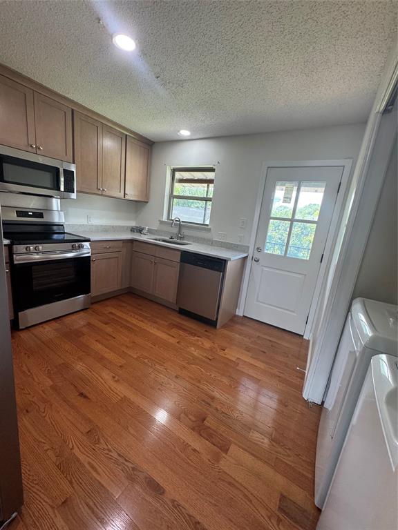 9519 Westpark Drive Benbrook, TX 76126 - Photo 4 of 9 a large kitchen with stainless steel appliances granite countertop a stove a sink dishwasher and a refrigerator with wooden floor