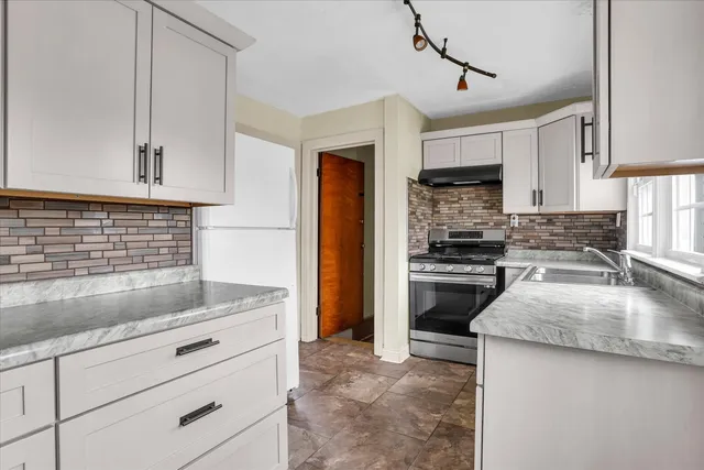 a kitchen with granite countertop a sink stainless steel appliances and cabinets