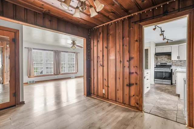 a view of a hallway with wooden floor and a kitchen