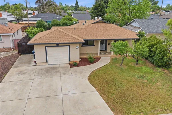 a view of a house with backyard and a garden