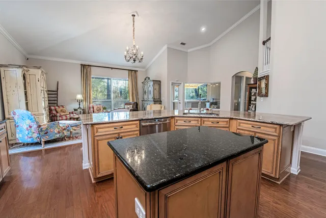 a view of kitchen with granite countertop a sink and a refrigerator
