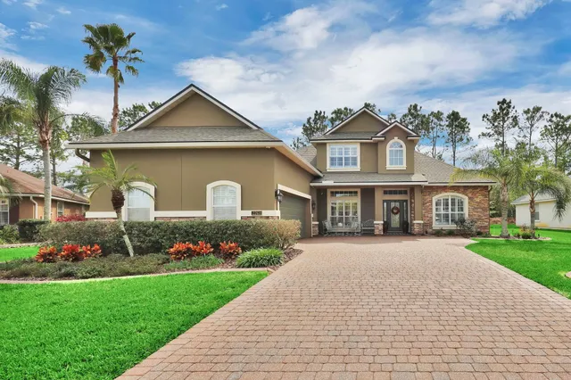 a front view of a house with a garden and plants