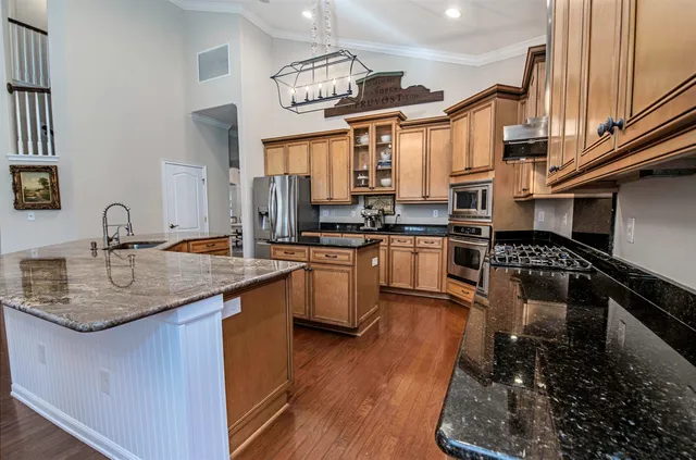 a kitchen with stainless steel appliances granite countertop a sink stove and refrigerator