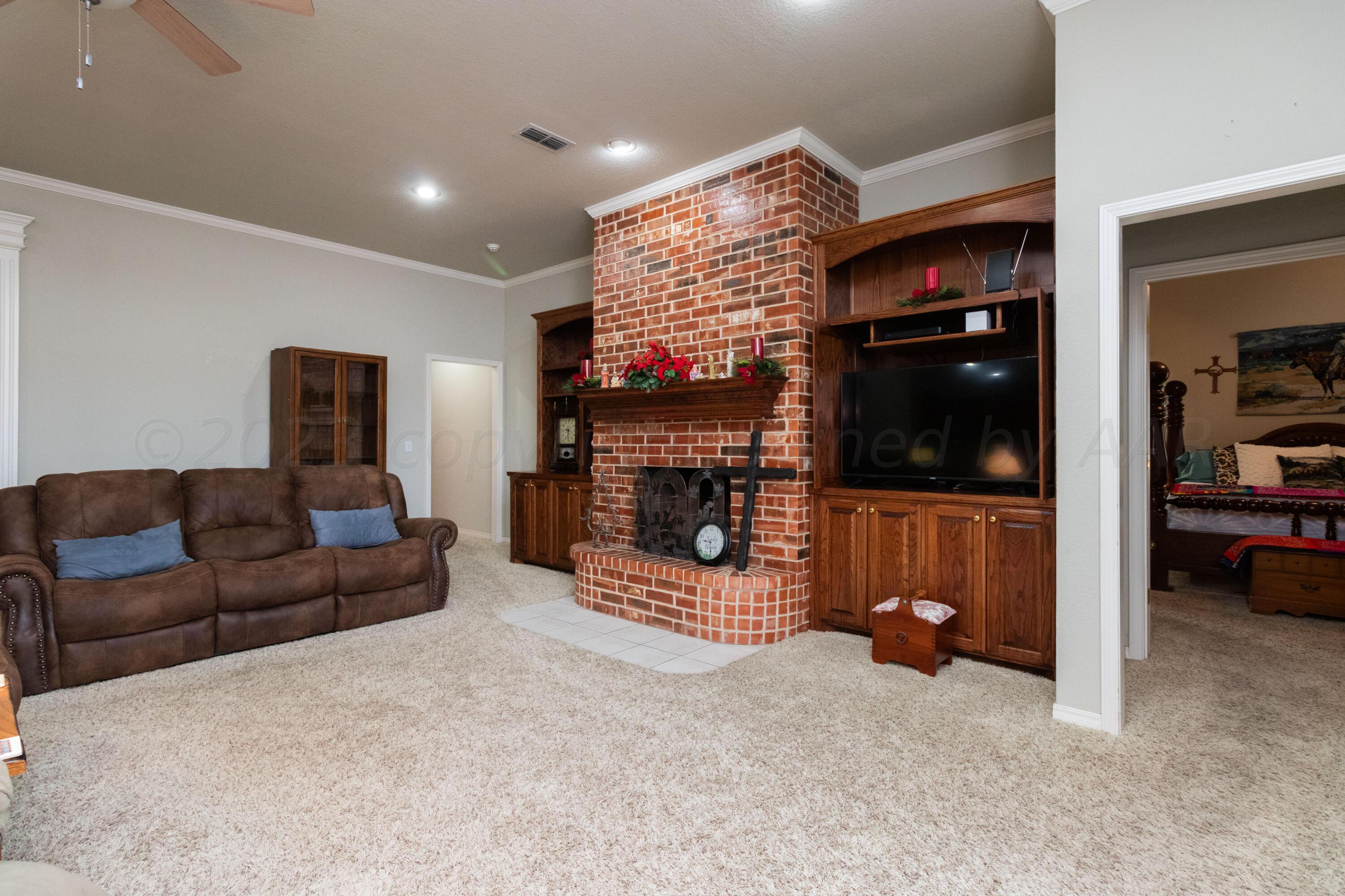 15212 Halsey Trail Amarillo, TX 79118 - Photo 9 of 47 a living room with furniture a flat screen tv and a fireplace