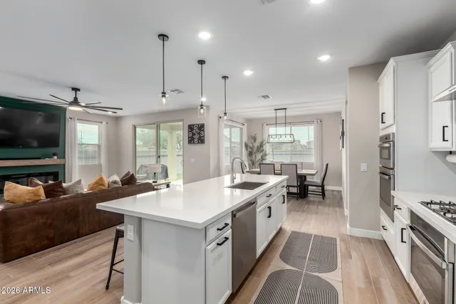 a large white kitchen with a large window and stainless steel appliances