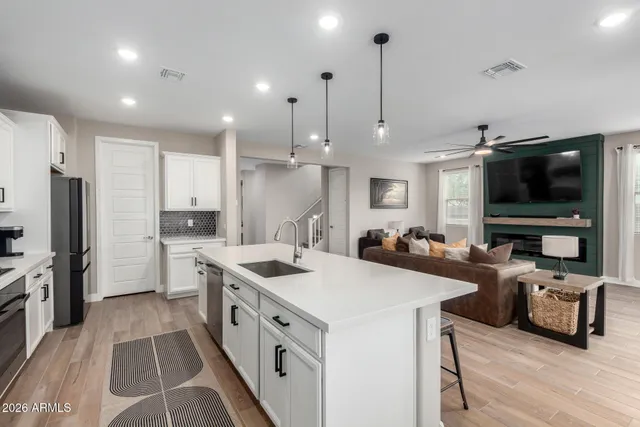 a kitchen with stainless steel appliances a stove a sink a microwave a refrigerator and cabinets