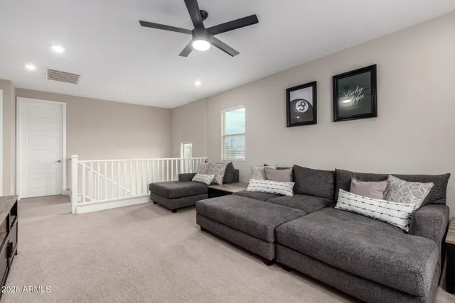 a living room with furniture and a ceiling fan