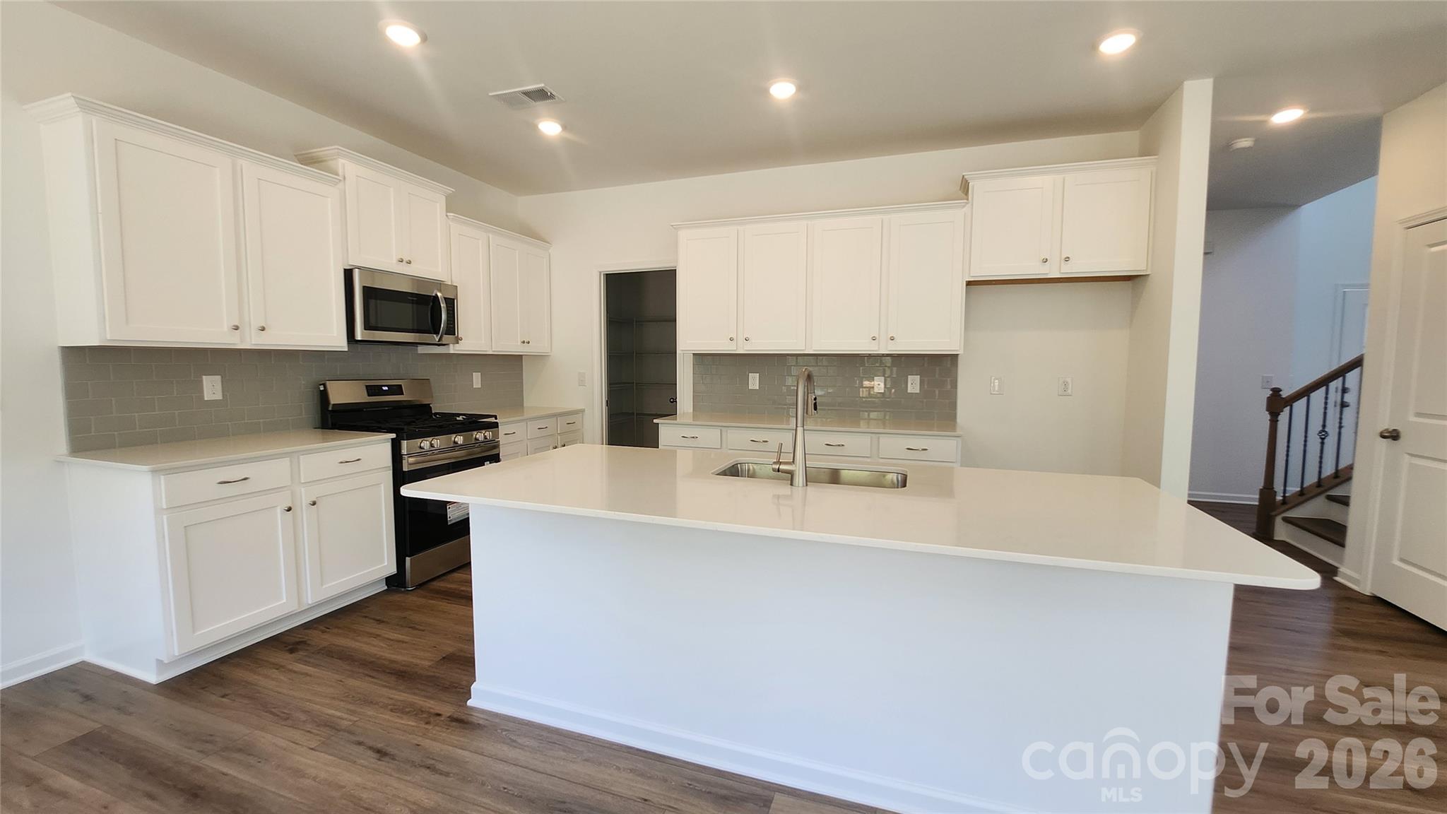 7032 Juneberry Way Maiden, NC 28650 - Photo 2 of 25 a kitchen with kitchen island a sink a stove a microwave and wooden floor