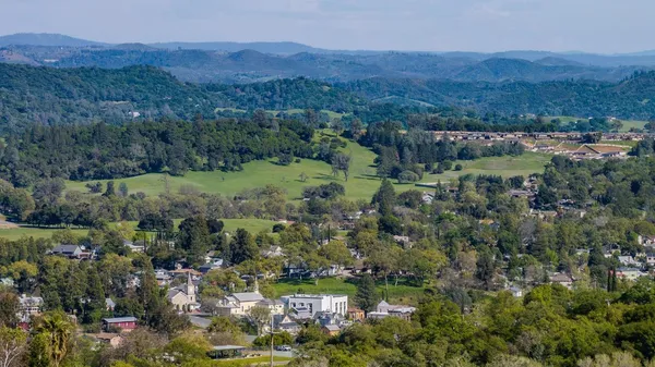 a view of a lush green hillside and houses