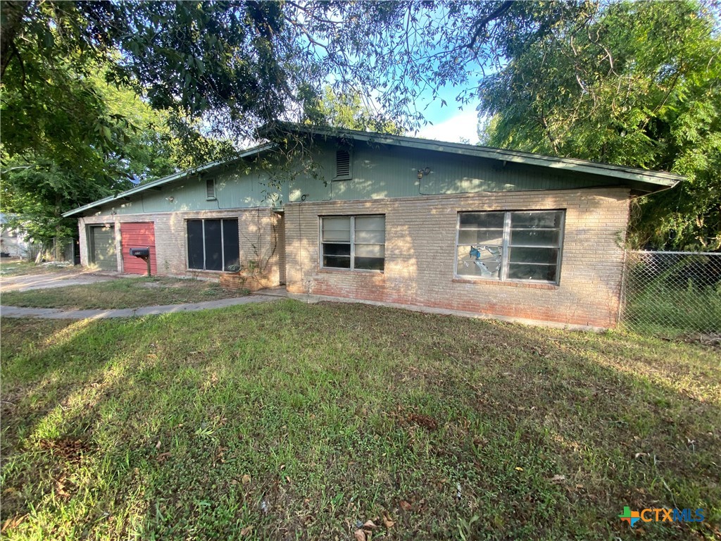 a front view of house with yard and trees around