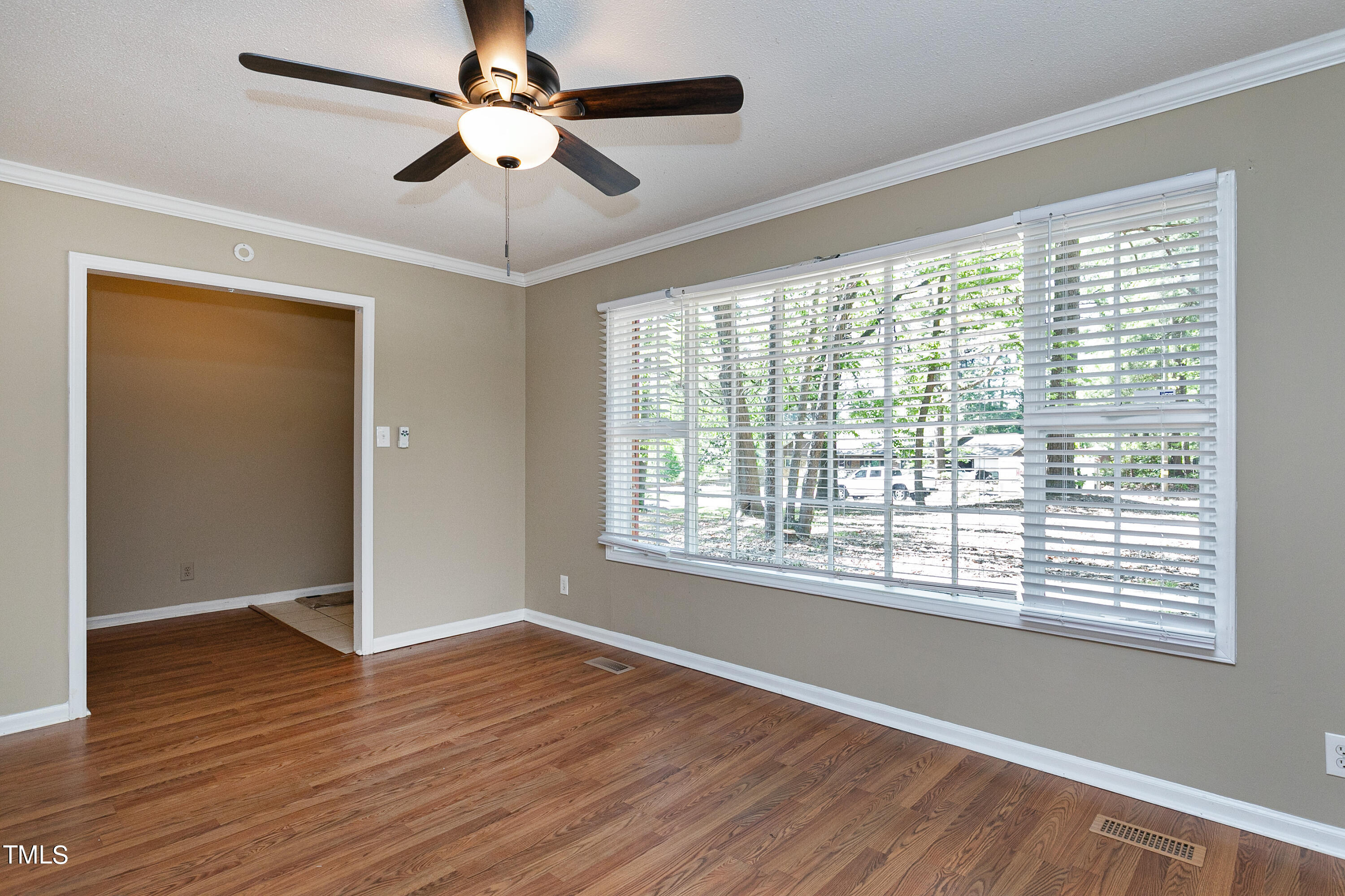 5841 Sandstone Drive Durham, NC 27713 - Photo 12 of 35 a view of an empty room with wooden floor and a window