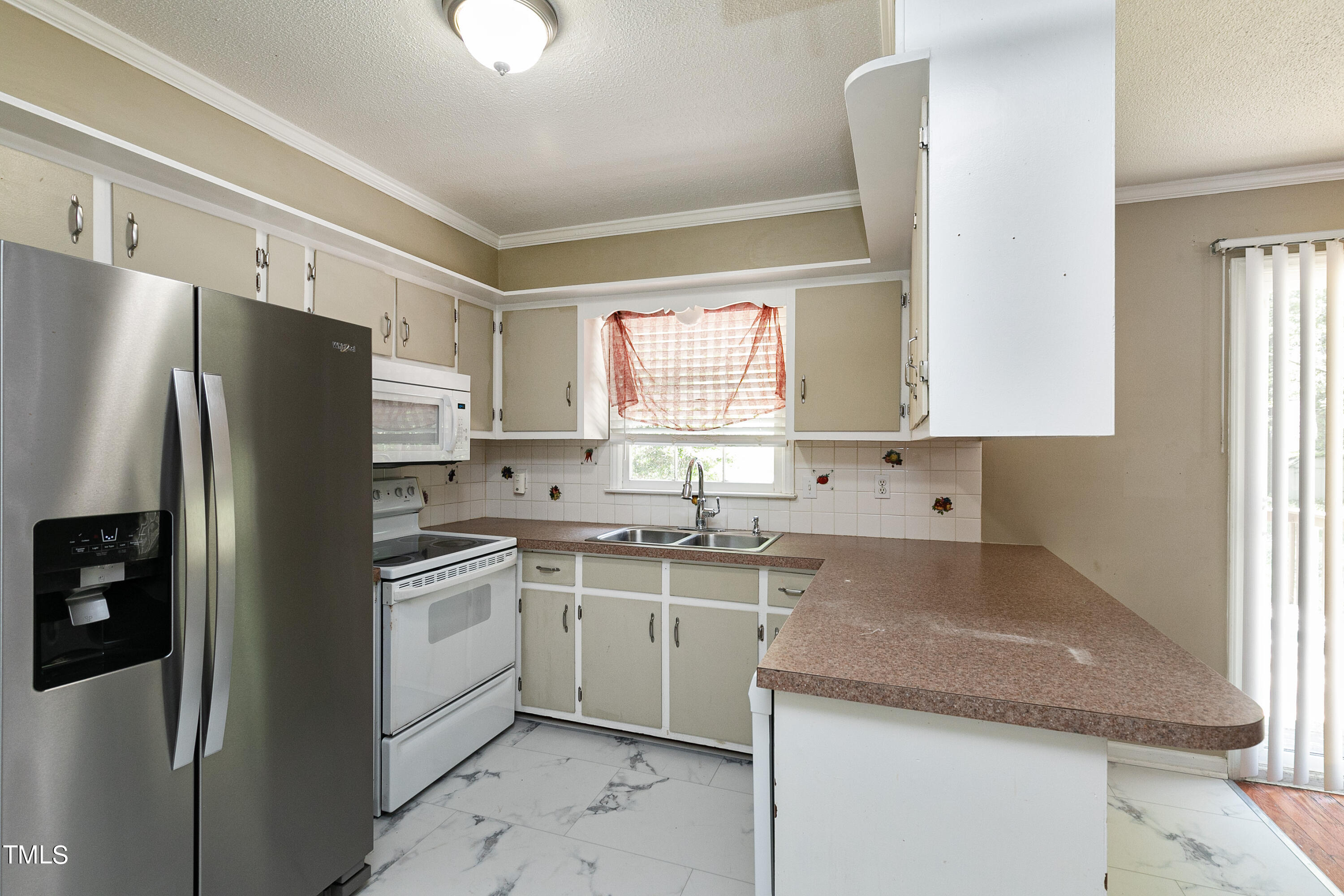 5841 Sandstone Drive Durham, NC 27713 - Photo 14 of 35 a kitchen with a sink a refrigerator and cabinets