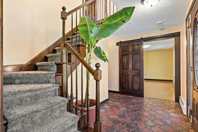 a view of an empty room with glass door and wooden floor