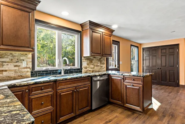 a kitchen with stainless steel appliances granite countertop a sink and wooden cabinets