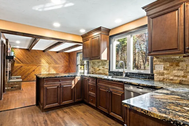 a kitchen with kitchen island granite countertop a stove and cabinets