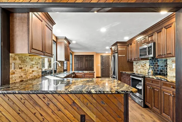 a kitchen with granite countertop a sink cabinets and stainless steel appliances
