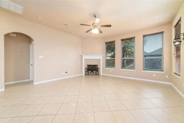 an empty room with windows and fireplace