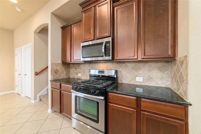 a kitchen with granite countertop cabinets stainless steel appliances and a counter space