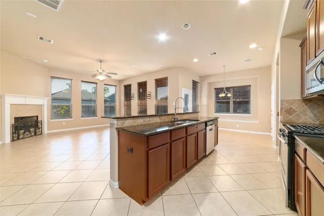 a large kitchen with granite countertop a stove and a sink