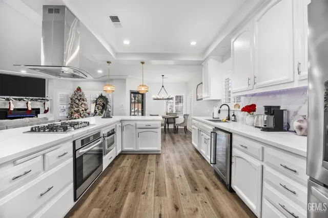 a large kitchen with stainless steel appliances lots of counter space and a sink